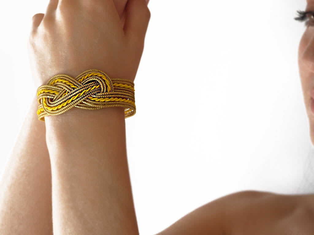 Pulsera tipo bracelete hecha a mano en oro vegetal y hilo de algodón amarillo. Cierre de mosquetón.